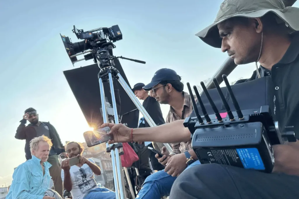 Camera operator and local
film crew members working with professional video equipment and a wireless transmission unit during a golden hour shoot in Nepal