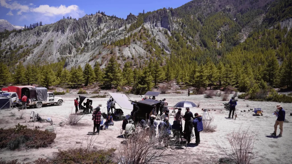 Film crew set up with equipment and vehicles in a rocky Himalayan valley during a production covered by film permits in Nepal