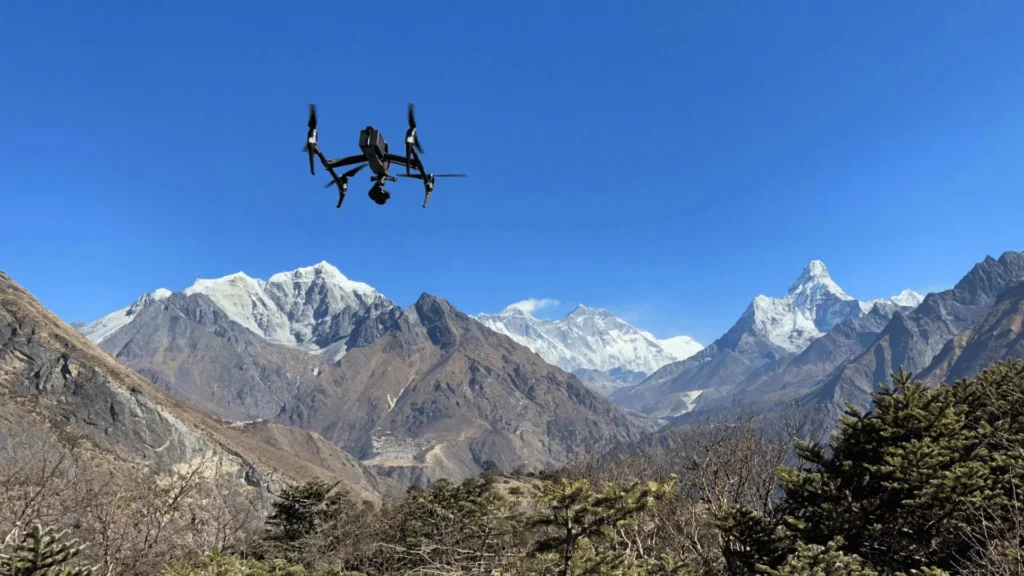 Professional cinema drone flying over snow-capped Himalayan peaks including Mount Everest under film permits and drone regulation in Nepal