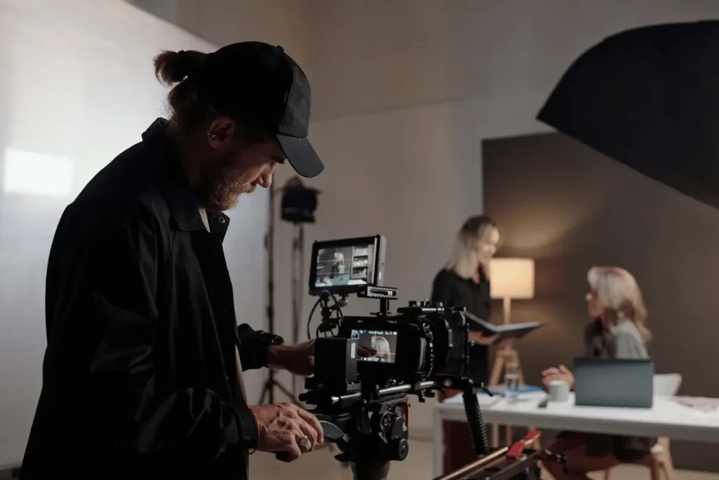 Professional cinematographer operating a rigged cinema camera on a studio production set for flimmakers