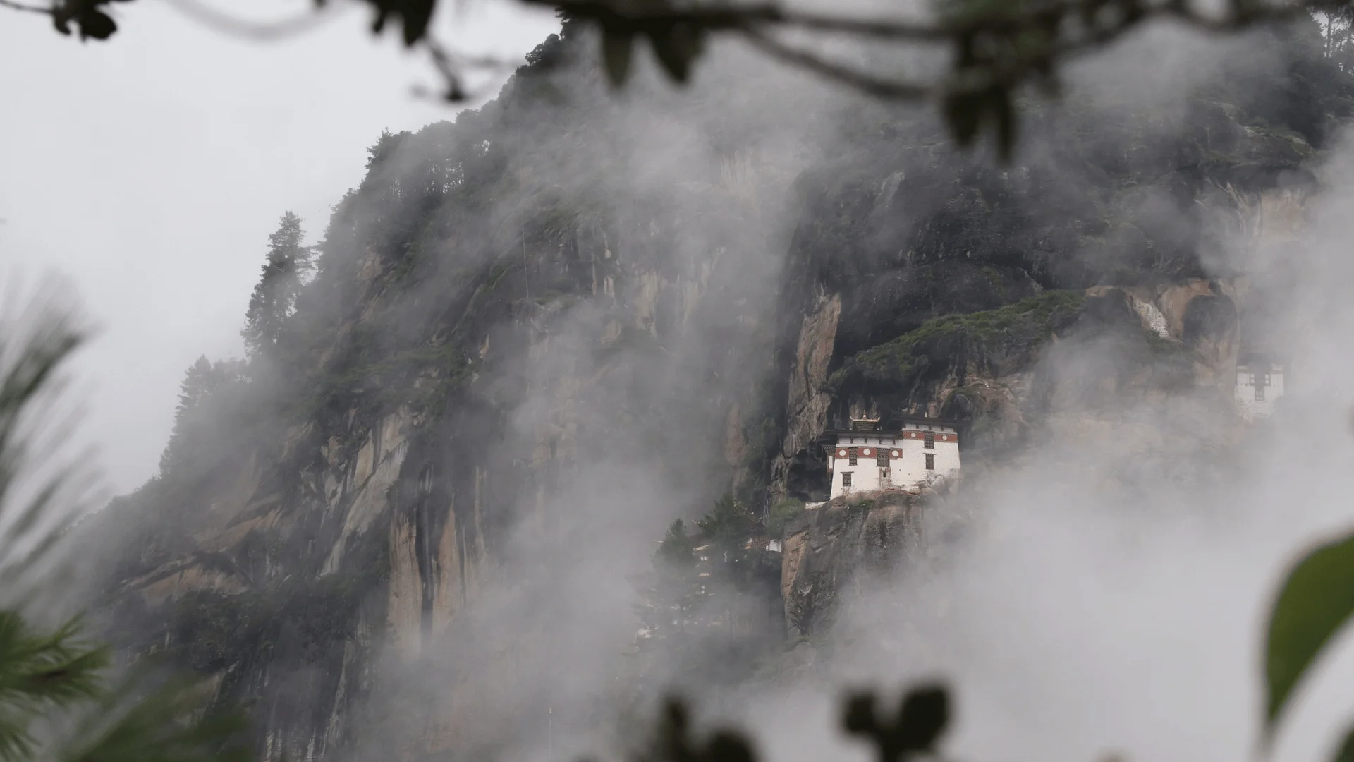 Nepal or Bhutan for high-altitude filming: Taktsang Palphug Monastery (Tiger's Nest) clinging to a misty cliffside in Paro, Bhutan.