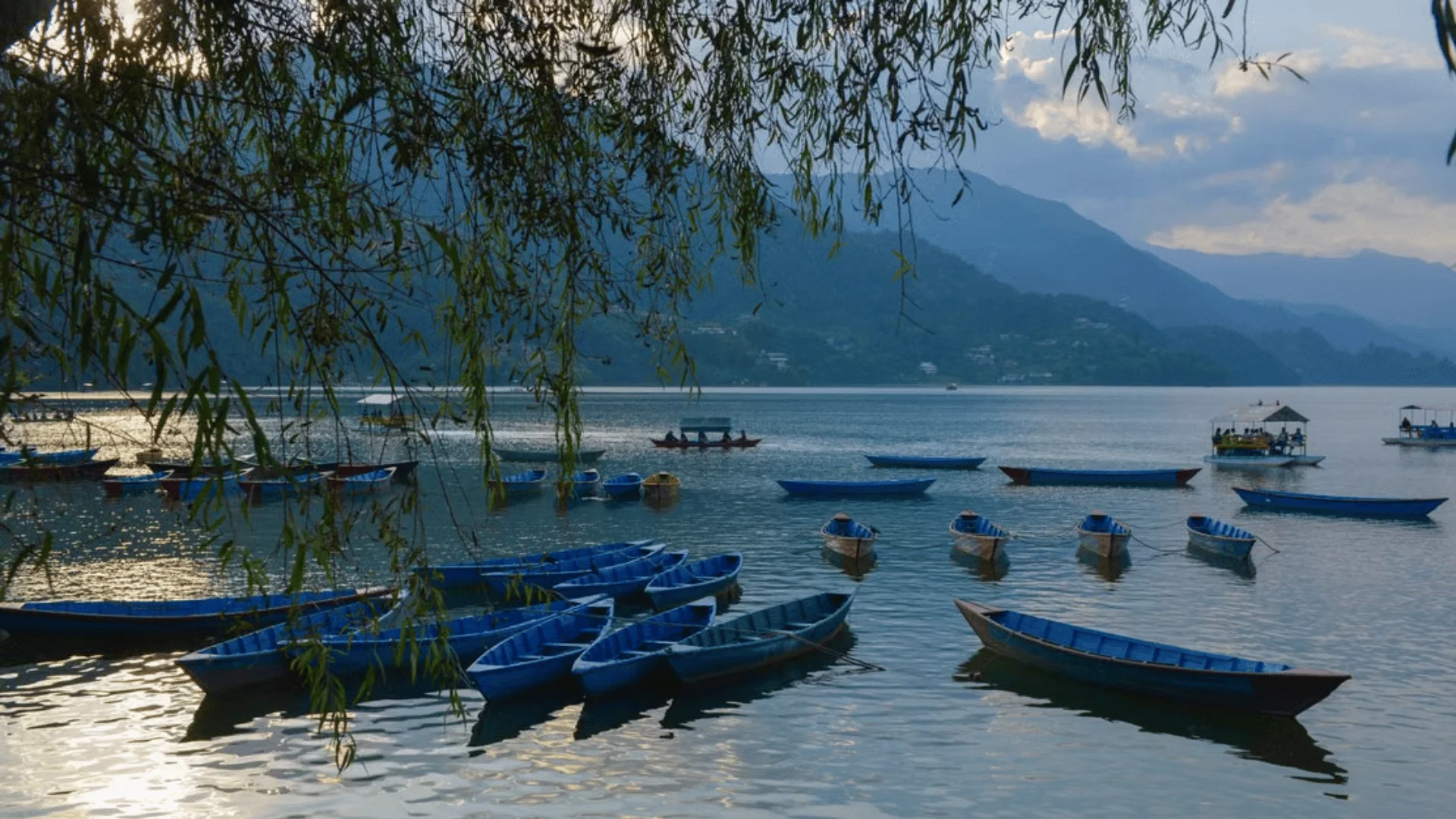 Blue boats on Phewa Lake at dusk, a popular location for filming in Pokhara, Nepal